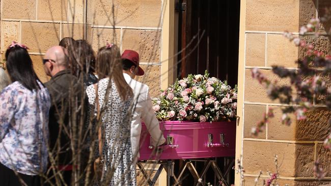 The bright Pink coffin adorned in roses was carried into the church. Picture: John Grainger