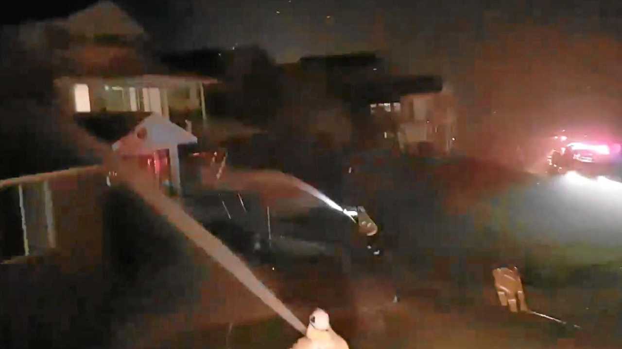 Firefighters hose down a line of houses in Angourie as fire embers shower down from an encroaching fire front on the night of Monday, 9th September, 2019. Picture: NSW RFS