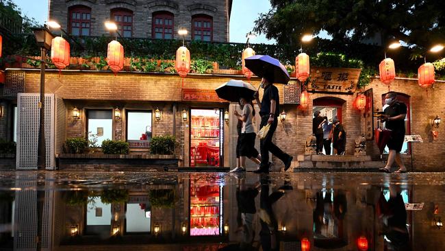 Pedestrians walk in the rain in Nanlouguxiang Alley, Beijing. Picture: Noel Celis/AFP