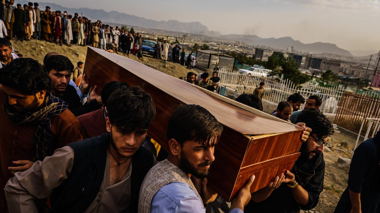 Caskets for the dead are carried towards the gravesite by grieving family and friends. Picture: Marcus Yam/Los Angeles Times