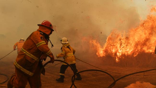 RFS Firefighters battle a spot fire on November 13, 2019 in Hillville near Taree. Catastrophic fire conditions have eased but dozens of bushfires are still burning. Picture: Getty