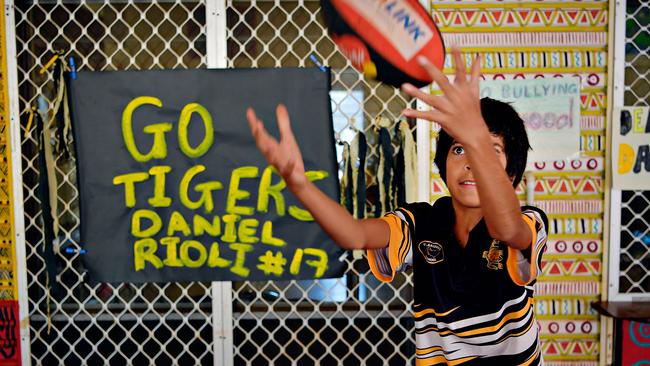 Sam Warrior from Pularumpi School standing with the poster she made supporting Daniel Rioli.