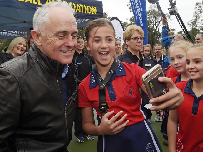 Australian Prime Minister Malcolm Turnbull shares takes a selfie with young netball players during visit to the HE Parker Netball Complex in Melbourne East. (AAP Image/Lukas Coch)