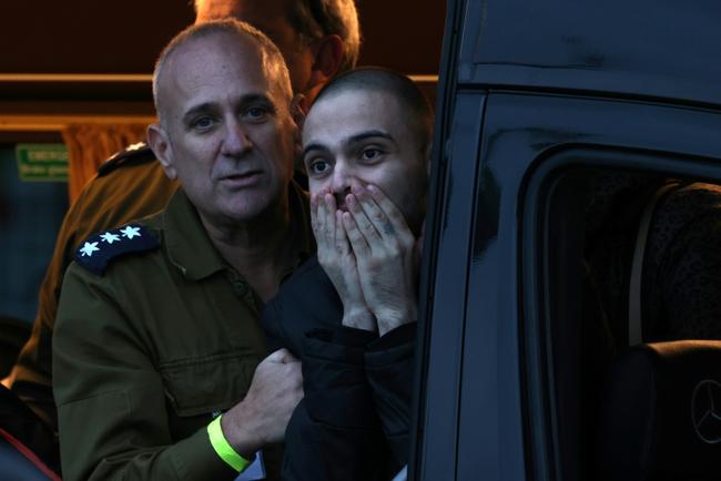 People view a makeshift memorial to Israeli hostages Ariel (L) and Kfir C-L) Bibas, Oded Lifshitz (top-C) and Shiri Bibas (below) at 'Hostages Square' in Tel Aviv, Israel, ahead of the latest hostage-prisoner swap