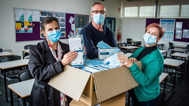 Thebarton Senior College Principal Eva Kannis-Torry, assistant principal Matt Fry and wellbeing leader Libby Branford, with a delivery of masks for students. Picture: Tom Huntley