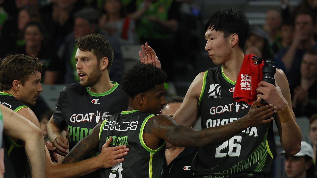 MELBOURNE, AUSTRALIA - DECEMBER 04: Zhou Qi of the Phoenix (R) high fives Xavier Munford of the Phoenix (C) as he comes to the bench during the round one NBL match between South East Melbourne Phoenix and New Zealand Breakers at John Cain Arena on December 04, 2021, in Melbourne, Australia. (Photo by Daniel Pockett/Getty Images)