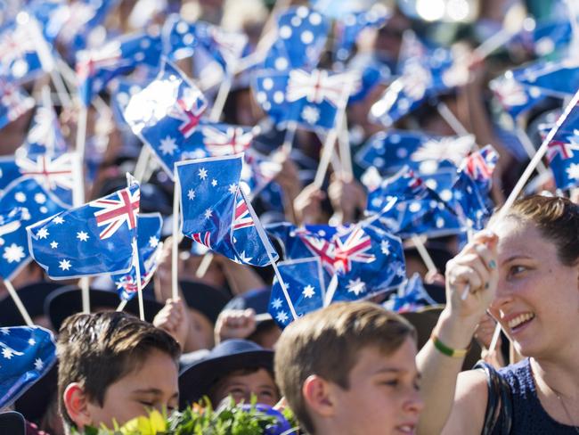 Crowds wave Australian Flags at the Caloundra Anzac Day Parade. Photo Lachie Millard