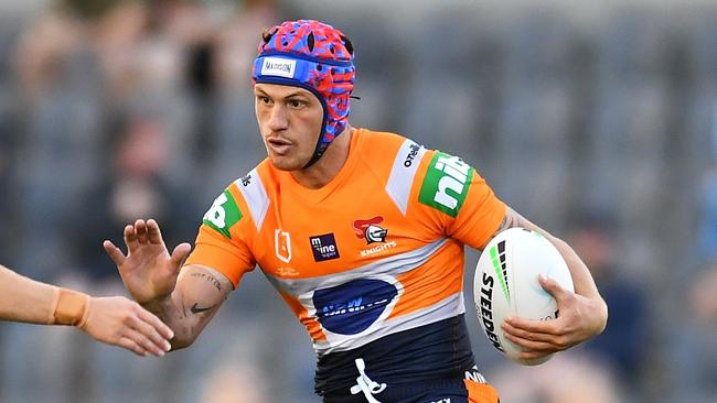 BRISBANE, AUSTRALIA - AUGUST 15:  Kalyn Ponga of the Knights breaks the tackle of Aiden Tolman and Toby Rudolf of the Sharks during the round 22 NRL match between the Cronulla Sharks and the Newcastle Knights at Moreton Daily Stadium, on August 15, 2021, in Brisbane, Australia. (Photo by Albert Perez/Getty Images)