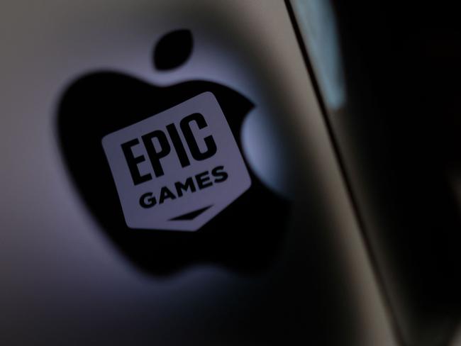 (FILES) This illustration photo shows the Epic Games logo reflecting onto the Apple logo of the back of an I-mac in Los Angeles on May 3, 2021. Epic Games, the maker of Fortnite, won a major US court battle against Google on December 11, when a jury decided that the search engine giant wields illegal monopoly power through its Android app store. Epic sued Google and Apple in 2020, accusing the tech titans of abusing control of their respective shops selling apps and other digital content for mobile devices powered by iOS or Android software. (Photo by Chris DELMAS / AFP)