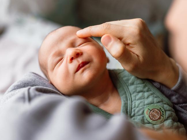 Mother holding her little cute sleeping baby boy