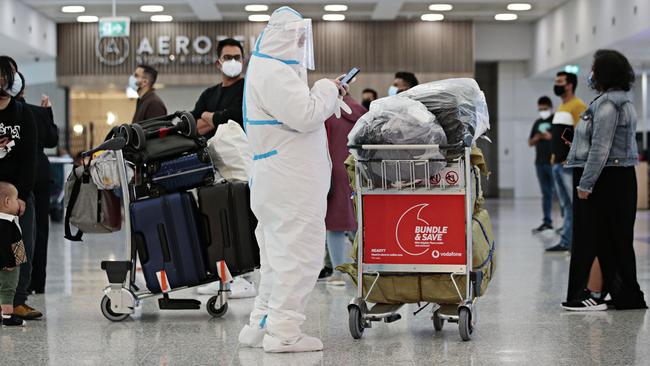 People in full PPE arriving at Sydney International Airport on Sunday morning. Picture: Adam Yip