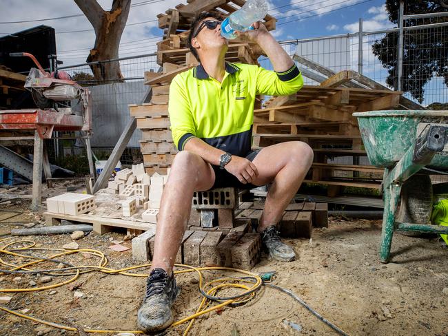 MELBOURNE, DECEMBER 15, 2022: Story on how long and more severe heat waves will impact Australian cities according to current climate trends. Thomas Charles, 33, cools off on a hot suburban work site. Picture: Mark Stewart