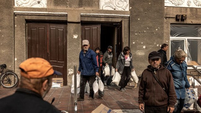 Lyman residents help themselves on Sunday to supplies abandoned by Russian forces. Picture: Manu Brabo for The Wall Street Journal