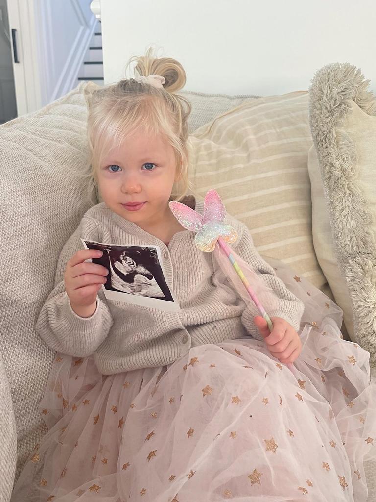 Piper Neale holds up an ultrasound image