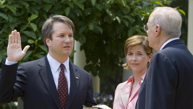 (FILES) In this file photo taken on June 01, 2006 Brett Kavanaugh (L) is sworn in as a US Court of Appeals Judge for the District of Columbia by US Supreme Court Justice Anthony Kennedy (R) as Kavanaugh's wife Ashley (C) holds the Bible during ceremonies 01 June 2006 in the Rose Garden of the White House in Washington, DC.  President Donald Trump will announce his US Supreme Court pick Monday July 9, an intensely anticipated decision likely to swing the bench rightward for years to come and which has Washington readying for an explosive confirmation battle. / AFP PHOTO / Paul J. RICHARDS