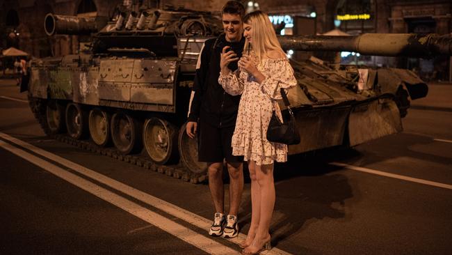 A couple takes a selfie by burnt-out Russian military vehicles displayed in central Kyiv ahead of Wednesday’s independence day. Picture: Getty Images