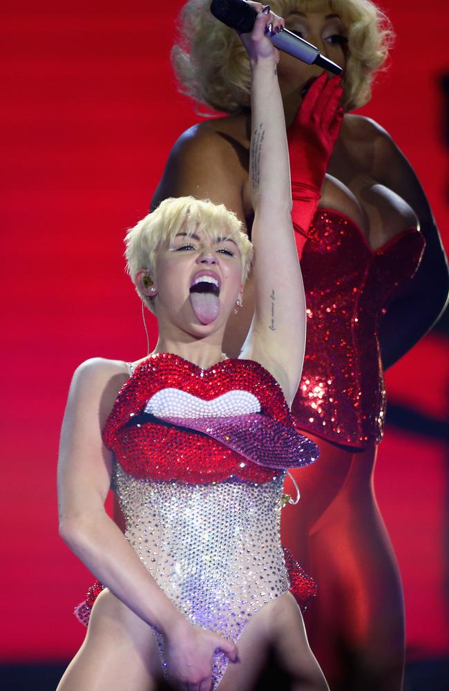 Tongue flash ... Miley Cyrus grabs her crotch during a dance routine in London.