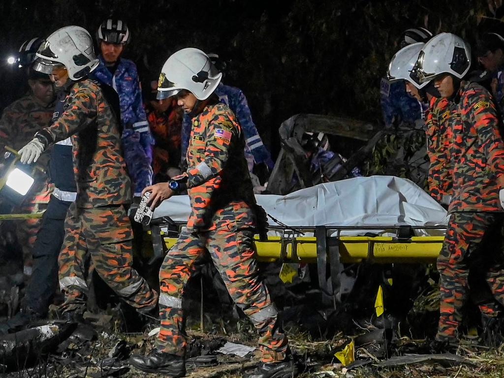 Members of the fire and rescue department carry a body from the crash site. (Photo by Muhammad Lutfi / AFP)