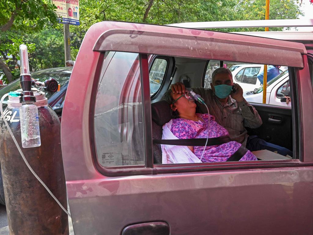 A patient breathes with the help of oxygen in a car. Picture: Prakash Singh