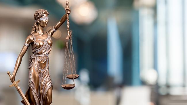 A bronze statue of the Lady Of Justice  composited into a blur background of a law firm. istock image