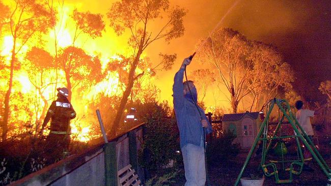 Firefighters and residents battle flames as fire threatened homes around Powderworks Rd at Ingleside in January, 2001. There wee concerns the proposed redevelopment could hamper bushfire evacuations. Picture: John Grainger