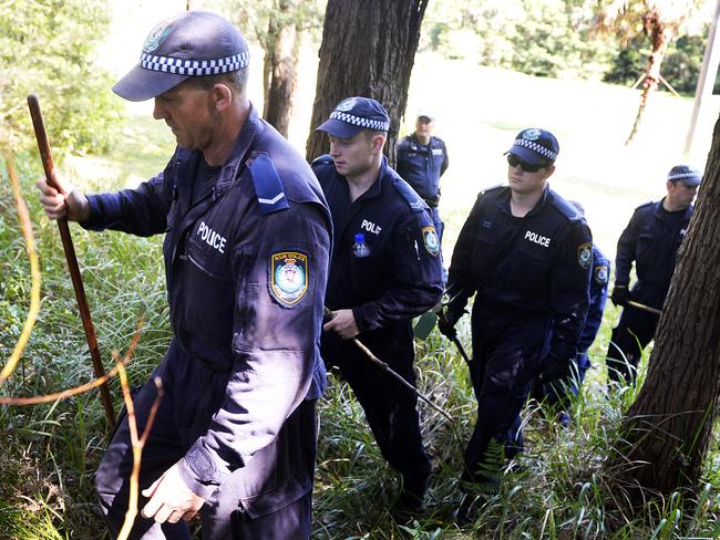 Tuggerah Lakes Police search bushland at Berkeley Vale near where Mr Penn’s burned out Mazda van was found in 1995.