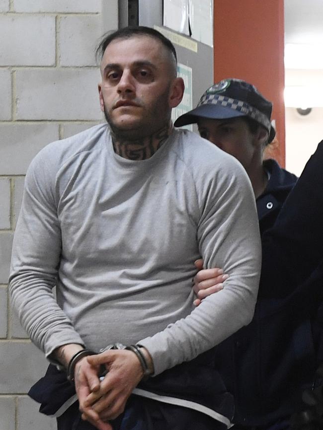 Yusuf Nazlioglu is escorted from Kogarah Police Station on Saturday morning. Picture: Gordon McComiskie