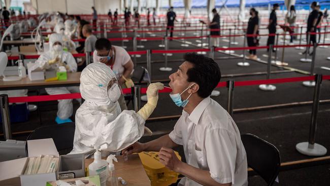 A health worker takes a swab during mass testing in Beijing. Picture: AFP