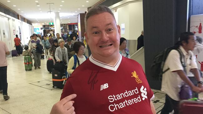 Liverpool fan Des Lloyd shows off his shirt with Jurgen Klopp's signature.