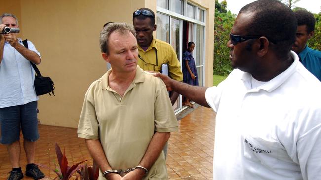 Peter Foster leaves with a correctional services guard, in handcuffs at the Port Villa magistrates court in Vanuatu for his hearing after arriving illegally from Fiji.