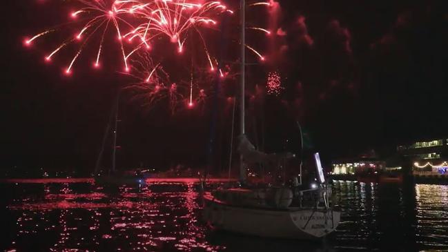 The final yacht in the Sydney to Hobart yacht race  Carrowong heads back to the docks as the fireworks light up the Hobart sky after finishing the race just before  midnight on New Year's Eve.Picture: Rolex Sydney Hobart Yacht Race