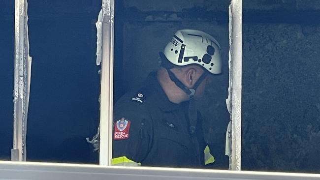 A firefighter surveys the damage in the bedroom.