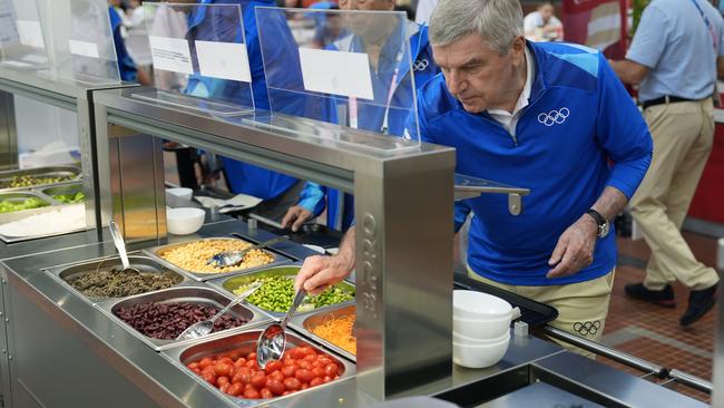 PARIS, FRANCE - JULY 22:  IOC President Thomas Bach tries food from a salad bar while touring the Olympic Village ahead of the start of the Paris 2024 Olympic Games on July 22, 2024 in Paris, France. (Photo by David Goldman - Pool/Getty Images)