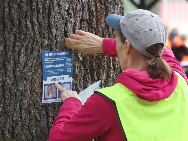 A Ground Crew volunteer sticks a missing person’s poster on a tree at Ballarat. Picture: NCA NewsWire / David Crosling