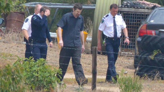 Gene Bristow, in blue short sleeved shirt, with sheriff’s officers on his property in Meningie. He has been found guilty of kidnapping and raping a backpacker at the property in 2017. Picture: Brenton Edwards