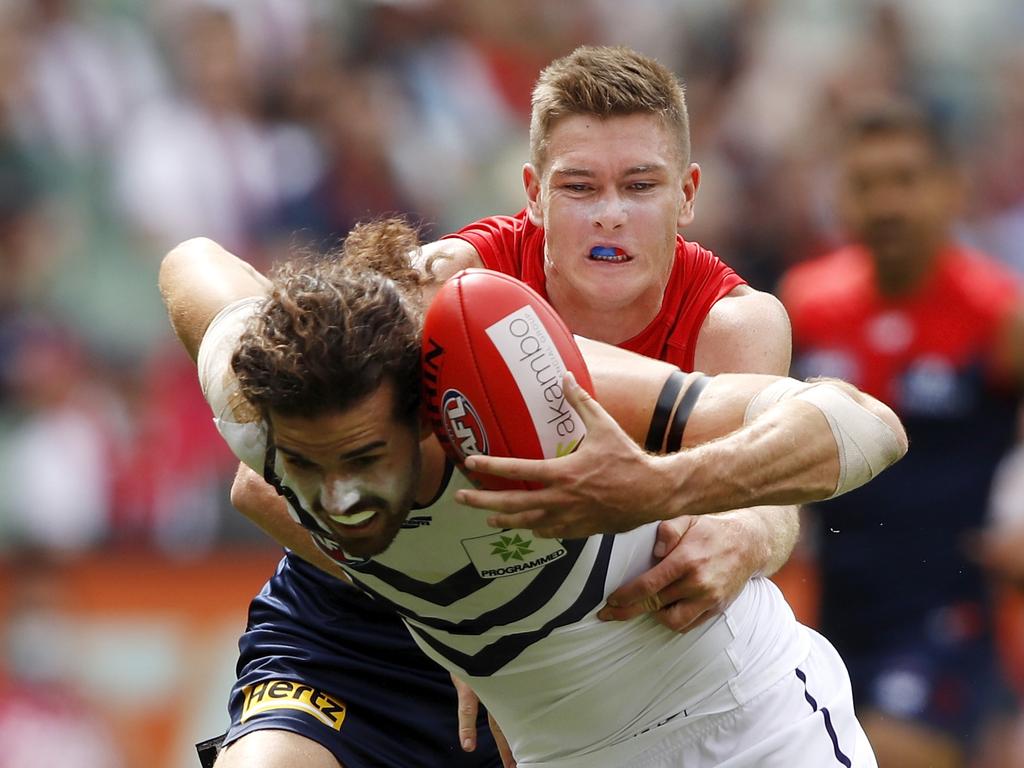 Alex Pearce of the Dockers is tackled by Adam Tomlinson of the Demons.