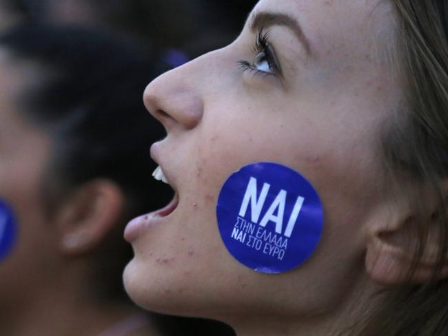 A demonstrator shouts slogans as the sticker on her cheek reading ''YES to Greece, Yes to Euro'' during a rally organized by supporters of the YES vote for the upcoming referendum in front of the Greek Parliament in Athens, Tuesday, June 30, 2015 Greece's European creditors were assessing a last-minute proposal Athens made for a new two-year rescue deal, submitted just hours before the country's international bailout program expires and it loses access to billions of euros in funds. (AP Photo/Petros Karadjias)