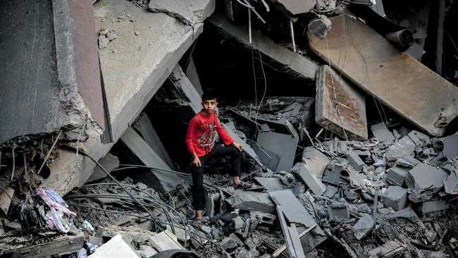 A young boy stands amid the rubble of a building in the aftermath of an Israeli strike on Gaza City on Thursday. Picture: AFP