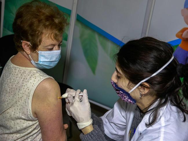 A health worker administers a dose of the Pfizer-BioNtech COVID-19 vaccine at Clalit Health Services in Jerusalem, on January 24, 2021. - Since the rollout of vaccinations one month ago, more than 2.5 million of Israel's nine-million-strong population have been vaccinated already, the health ministry said on January 22. (Photo by MENAHEM KAHANA / AFP)