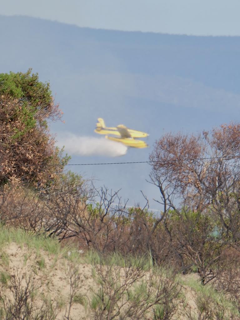 Water bombing runs made to tame a bushfire threatening Dolphin Sands in the early morning. Picture: Tony Fist