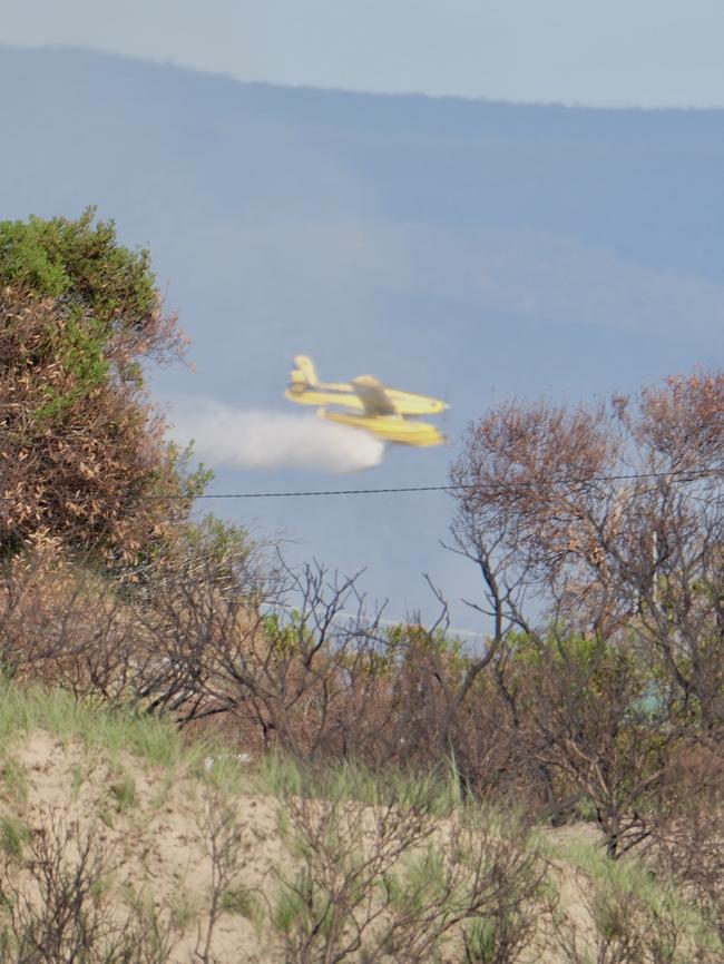 Water bombing runs made to tame a bushfire threatening Dolphin Sands in the early morning. Picture: Tony Fist