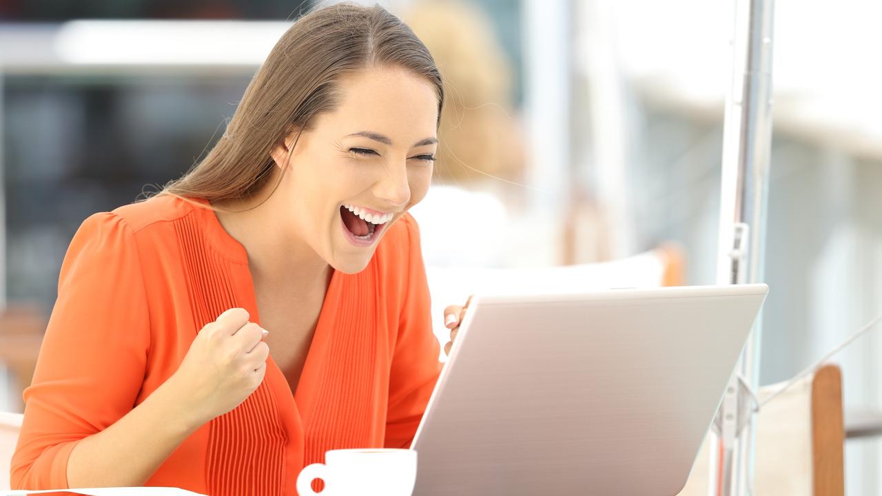 IMAGES FOR NEWS.COM.AU COMMENT MODERATION STORY - THIS IS 'TRISH' -  Single excited entrepreneur receiving good news on line in a laptop sitting in a restaurant terrace  Picture: istock