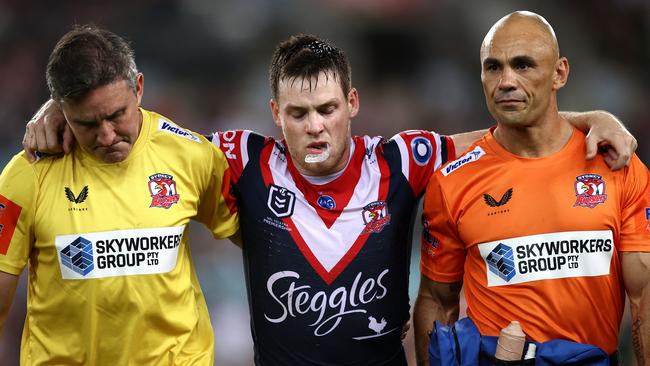 Luke Keary of the Roosters is helped off the field after injuring his knee. Picture: Cameron Spencer/Getty Images