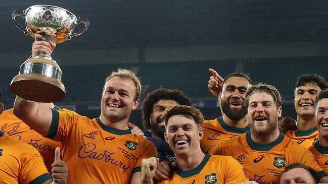 Australia's captain Harry Wilson holds the Ella-Mobbs Trophy as Australia's players pose after their win in the Autumn Nations Series International rugby union test match between England and Australia at the Allianz Stadium, Twickenham in south-west London, on November 9, 2024. Australia won the game 42-37. (Photo by Adrian Dennis / AFP)