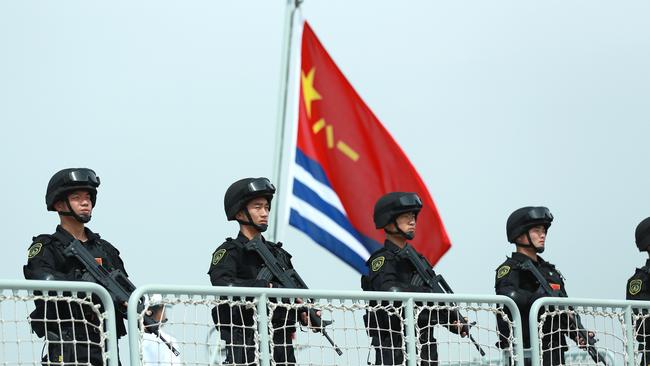 Members of the Chines Navy stand on the deck of a navy ship at a military port in Zhejiang Province. Picture: VCG/VCG via Getty Images.