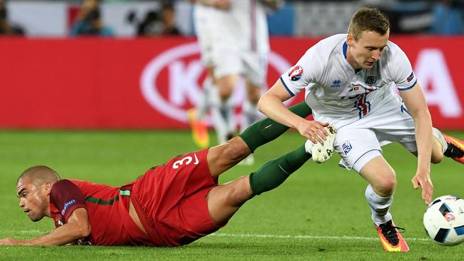 Portugal's defender Pepe (L) is tackled by Iceland's forward Jon Dadi Bodvarsson.