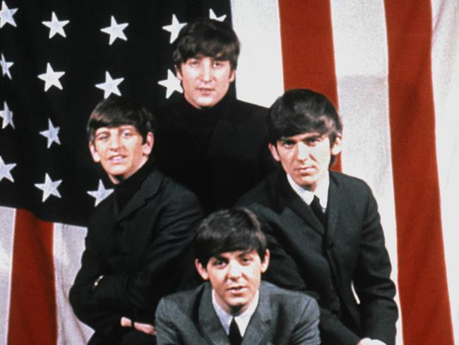 The Beatles pose for a portrait in front of an American Flag, New York City, 1964. Clockwise from top: John Lennon (1940 - 1980), George Harrison (1943 - 2001), Paul McCartney and Ringo Starr. (Photo by Michael Ochs Archives/Getty Images)