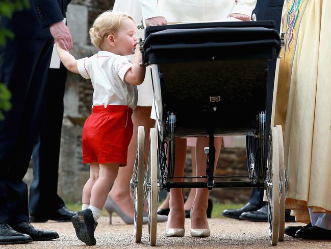 Prince George of Cambridge looks at his sister as his mother, Britain’s Catherine, Duchess of Cambridge, pushes her daughter, Princess Charlotte of Cambridge in her pram as they leave Charlotte’s Christening at St. Mary Magdalene Church in Sandringham, England, on July 5, 2015. Picture: AFP
