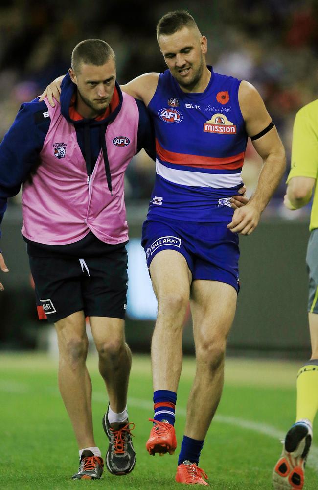 Matthew Suckling is helped from the ground after injuring his knee and ankle. Picture: Wayne Ludbey