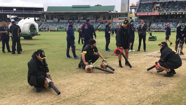 WACA groundstaff dry out the pitch.